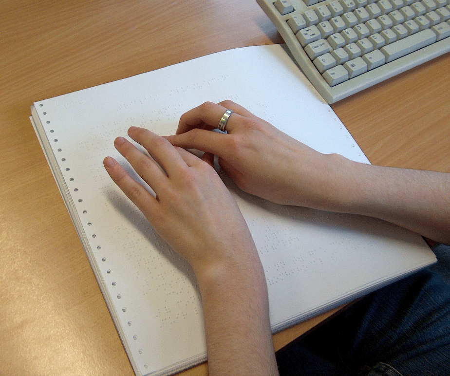 Braille Proofreader checking book. Click on image to enlarge.